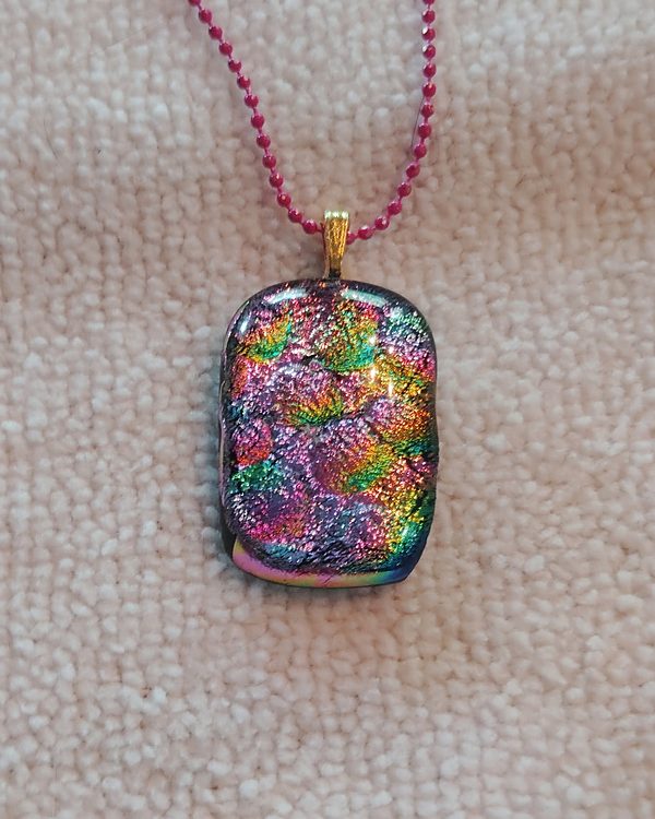 Small rectangular glass pendant covered in rainbow sparkle, on a pink ball chain